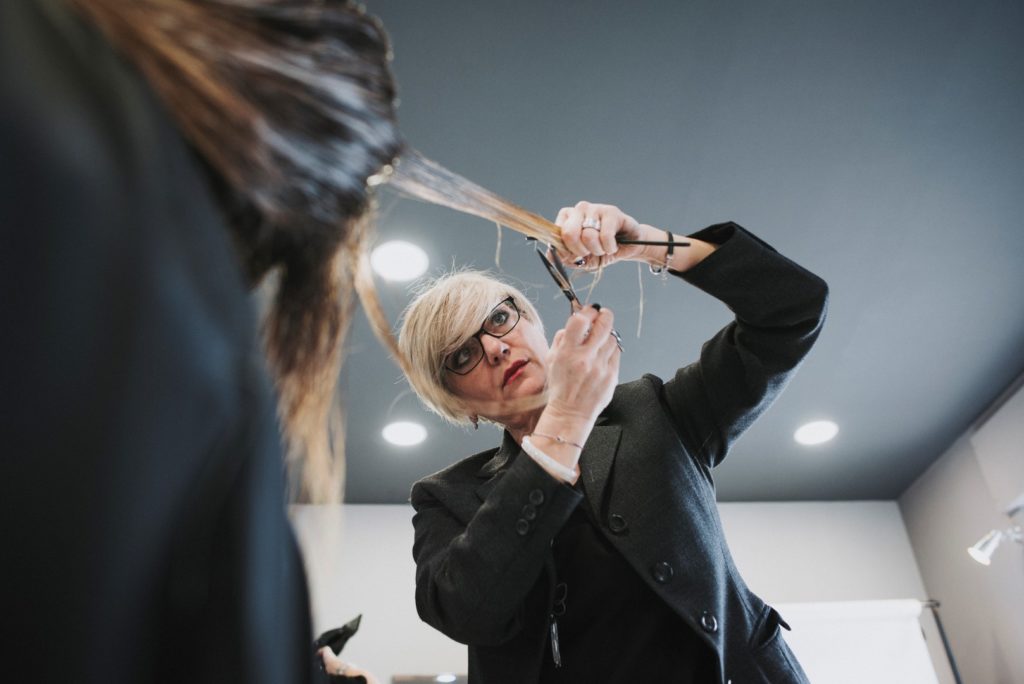 Parrucchiera che taglia i capelli a una cliente